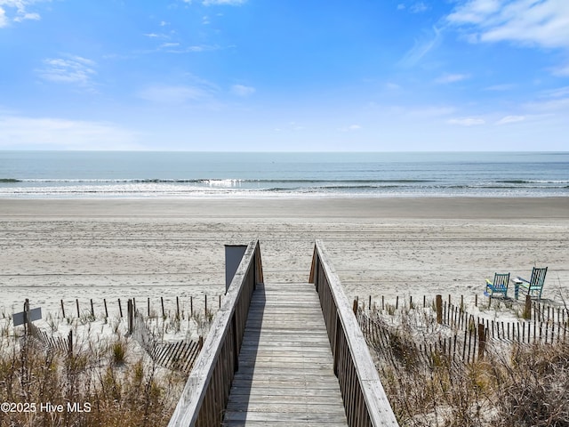 view of property's community with a water view and a beach view