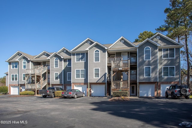 townhome / multi-family property with brick siding, driveway, and an attached garage