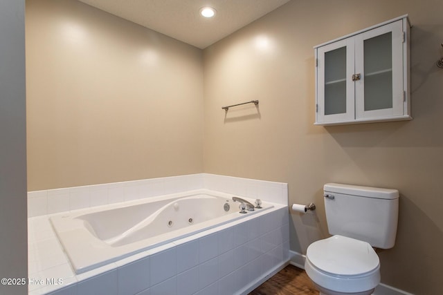 full bath featuring recessed lighting, a whirlpool tub, toilet, and wood finished floors