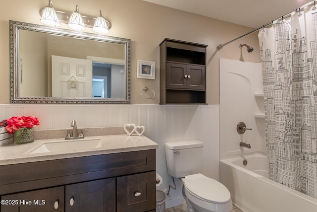 full bath with a wainscoted wall, shower / tub combo, vanity, and toilet