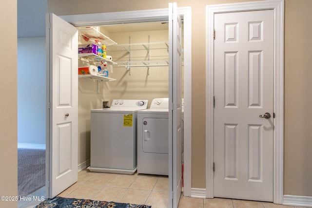 washroom featuring laundry area, light tile patterned floors, baseboards, and separate washer and dryer