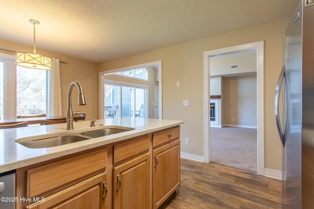 kitchen with a textured ceiling, a wealth of natural light, a sink, and freestanding refrigerator