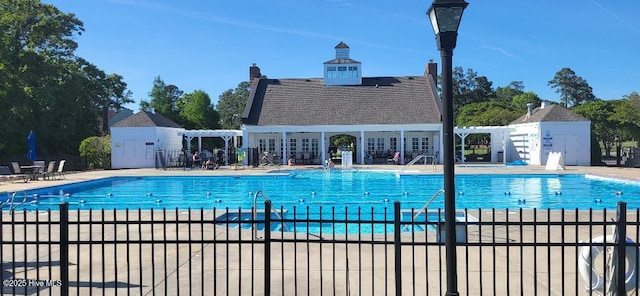 pool with a patio area and fence