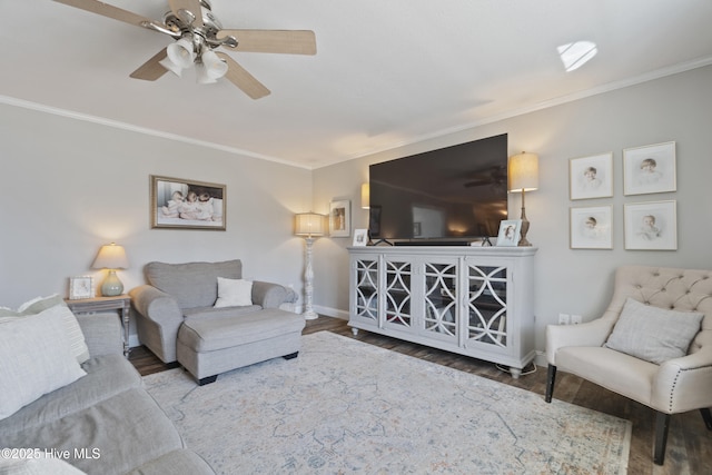 living room featuring ceiling fan, crown molding, baseboards, and wood finished floors