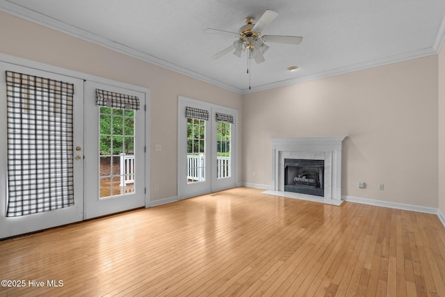 10 Lodge Pole Ln, Pinehurst, NC 28374 - unfurnished living room featuring ornamental molding, light wood-style flooring, ceiling fan, a premium fireplace, and baseboards