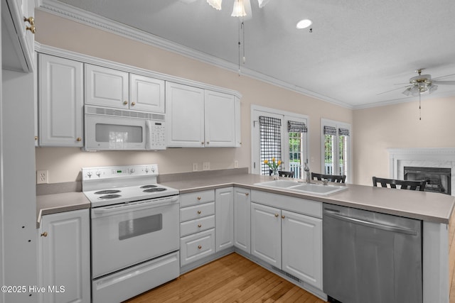 10 Lodge Pole Ln, Pinehurst, NC 28374 - kitchen with white appliances, ceiling fan, a sink, a peninsula, and crown molding