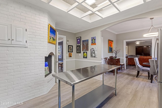 game room with arched walkways, brick wall, coffered ceiling, light wood-style floors, and crown molding