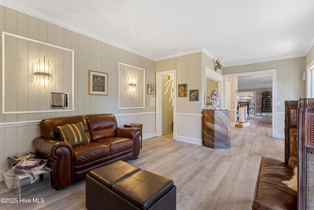 living room featuring ornamental molding, a stone fireplace, and wood finished floors