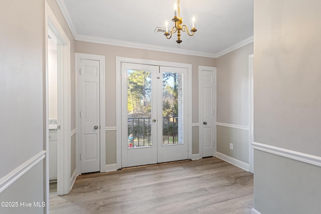 entryway featuring visible vents, ornamental molding, wood finished floors, french doors, and a chandelier