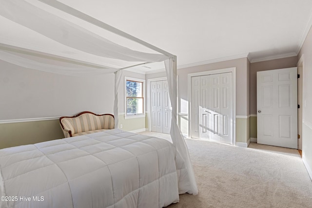 bedroom with multiple closets, carpet, crown molding, and baseboards