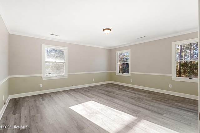 empty room with a healthy amount of sunlight, baseboards, and wood finished floors