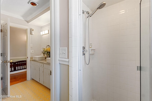 bathroom featuring a shower stall, ornamental molding, and vanity