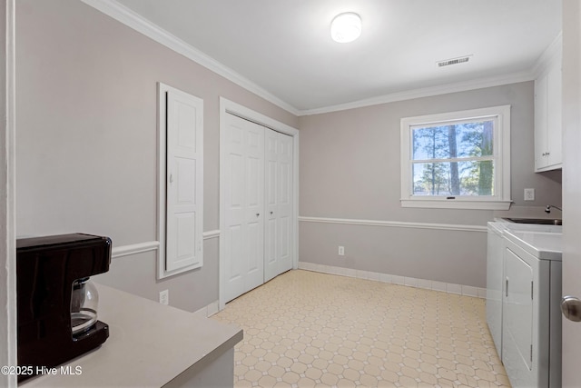 clothes washing area with cabinet space, baseboards, ornamental molding, and washer and dryer