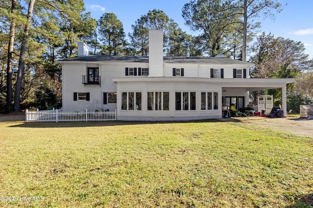 back of house featuring a chimney, fence, and a lawn