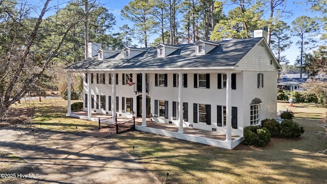 view of front facade with a front lawn, a chimney, and a patio area