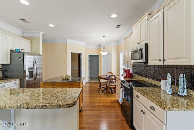 kitchen featuring stainless steel appliances, a kitchen island, visible vents, and crown molding