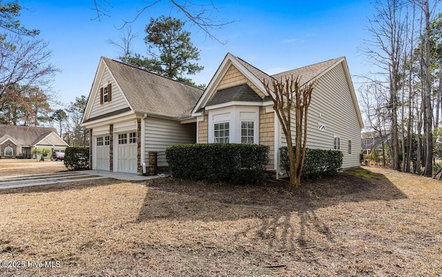 view of front facade featuring a garage, driveway, and a shingled roof