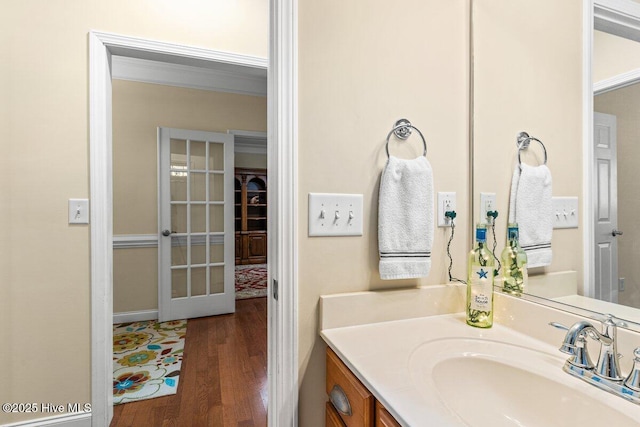 bathroom featuring ornamental molding, french doors, wood finished floors, and vanity