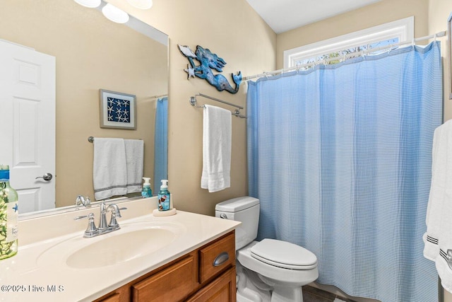 bathroom featuring toilet, curtained shower, and vanity