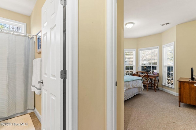 ensuite bathroom featuring a healthy amount of sunlight, a shower with curtain, baseboards, and connected bathroom