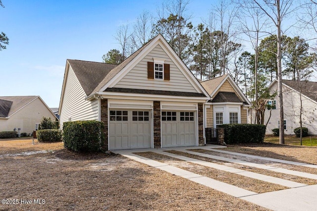 view of front of house featuring a garage, stone siding, roof with shingles, and concrete driveway