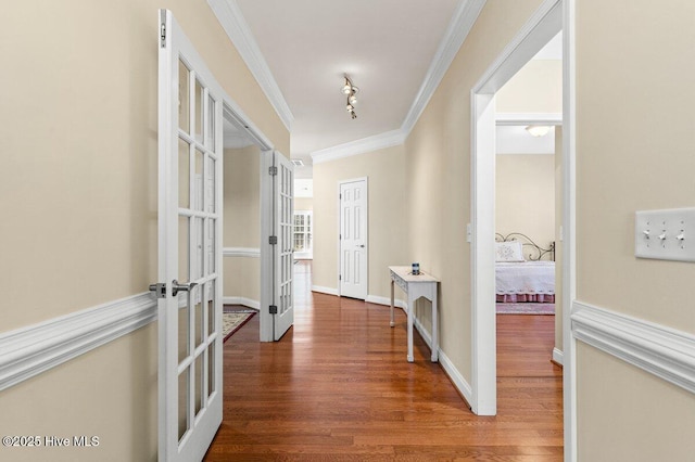 hallway featuring ornamental molding, french doors, wood finished floors, and baseboards