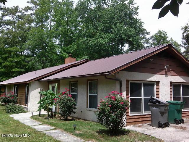 5200 Pineview Rd, Lumberton, NC 28360 - view of front of property featuring a chimney, metal roof, and stucco siding