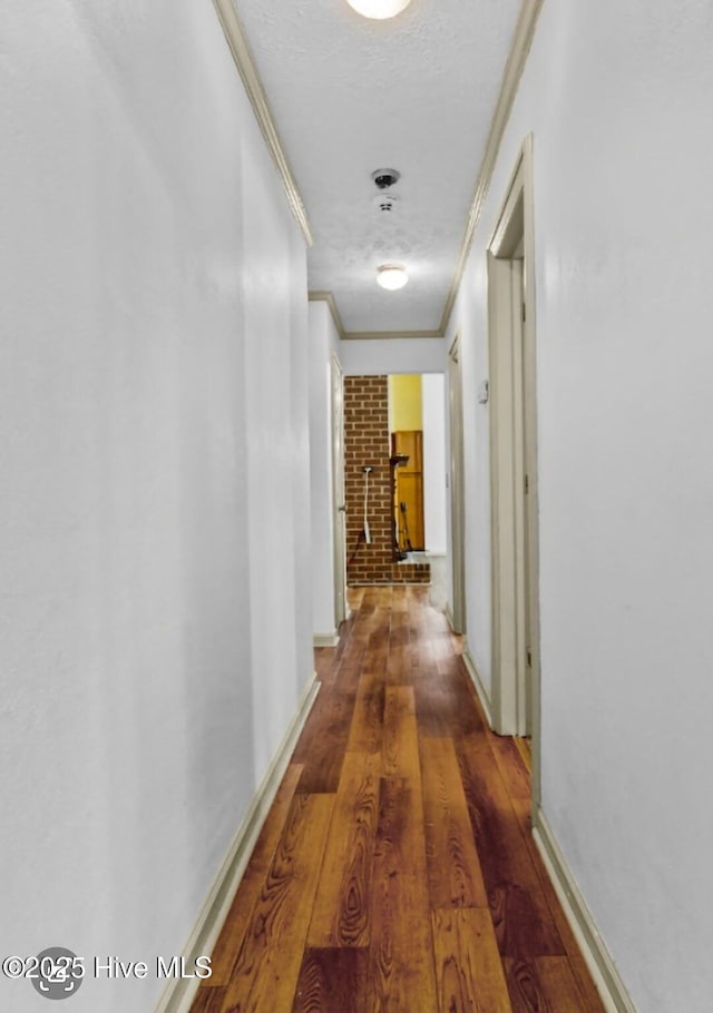 5200 Pineview Rd, Lumberton, NC 28360 - corridor with crown molding, wood finished floors, baseboards, a textured ceiling, and brick wall