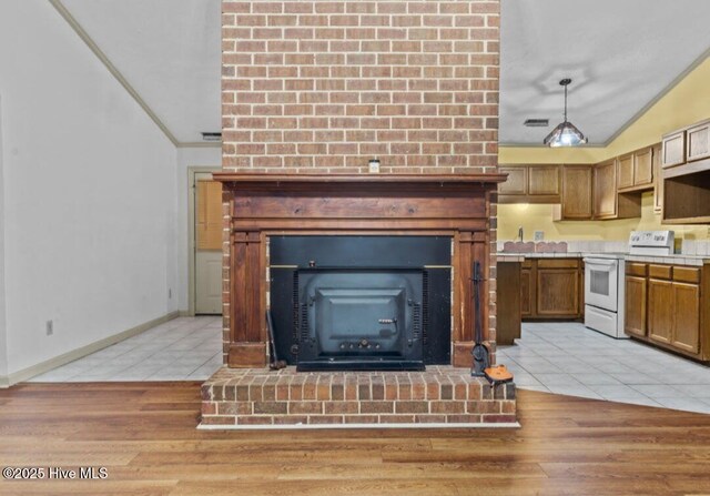 5200 Pineview Rd, Lumberton, NC 28360 - kitchen with white electric stove, light tile patterned floors, a fireplace, lofted ceiling, and light countertops
