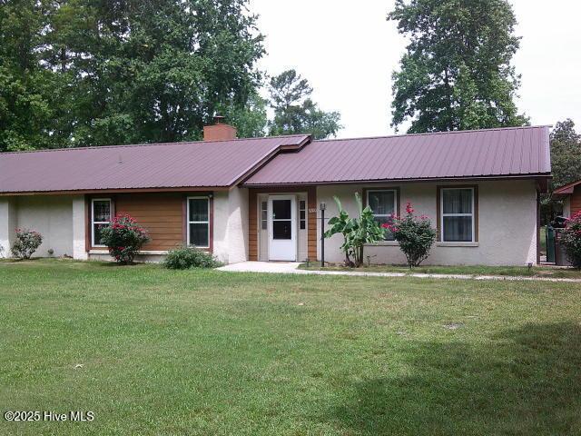 5200 Pineview Rd, Lumberton, NC 28360 - ranch-style home with stucco siding, a front lawn, a chimney, and metal roof