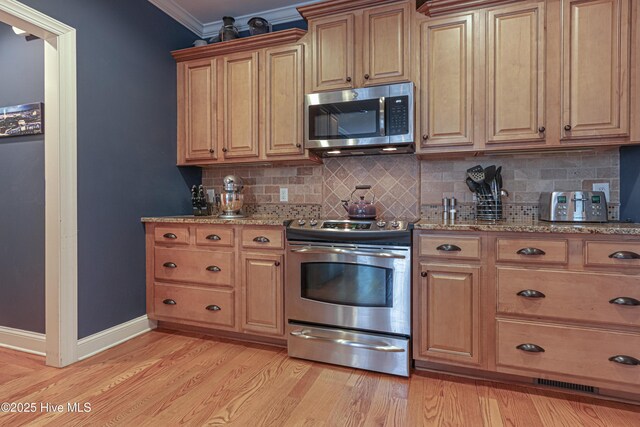 kitchen with light wood-type flooring, decorative backsplash, stainless steel appliances, and crown molding