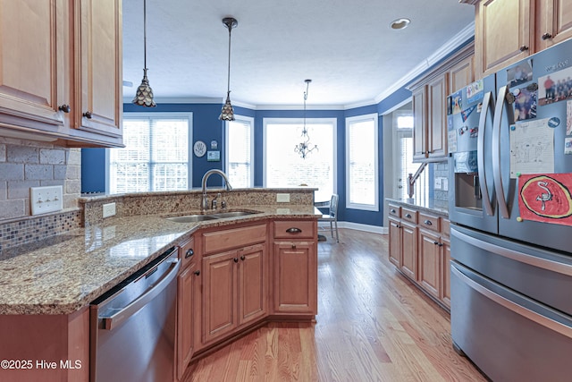 kitchen with tasteful backsplash, appliances with stainless steel finishes, ornamental molding, a peninsula, and a sink