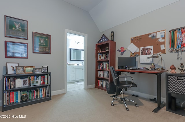 carpeted home office featuring baseboards and vaulted ceiling