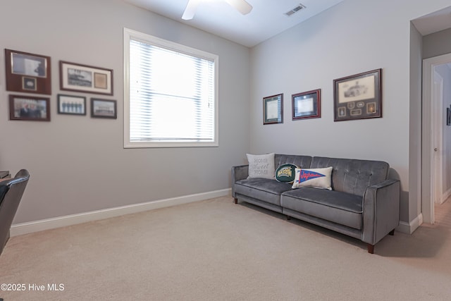 living area with baseboards, visible vents, ceiling fan, and carpet flooring