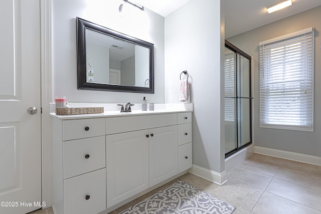 bathroom featuring visible vents, baseboards, a shower with shower door, tile patterned floors, and vanity