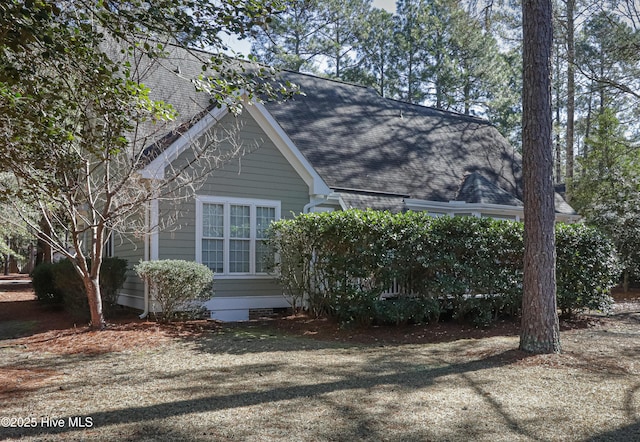 view of side of property with roof with shingles