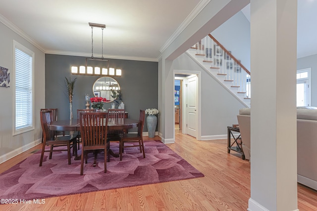 dining space featuring ornamental molding, baseboards, and wood finished floors