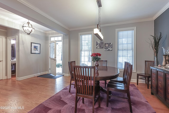 dining room with baseboards, ornamental molding, and light wood-style floors