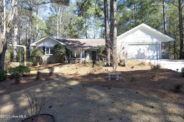 ranch-style house featuring concrete driveway and an attached garage