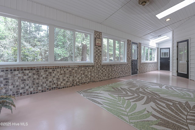 unfurnished sunroom with a skylight