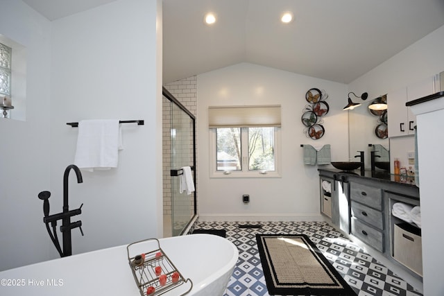 bathroom featuring vaulted ceiling, a soaking tub, a shower stall, and vanity