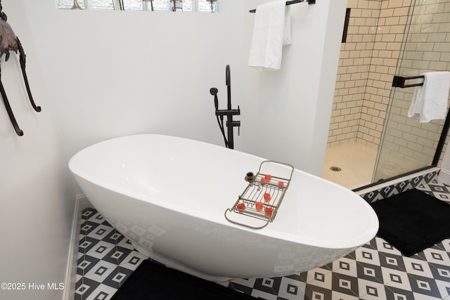 bathroom with a soaking tub and a shower stall