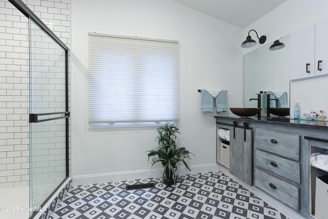 bathroom featuring baseboards, a stall shower, and vanity