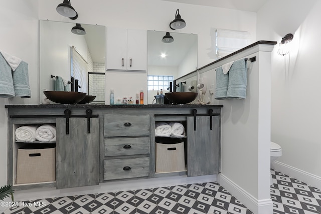 full bath with tile patterned floors, toilet, vanity, and baseboards