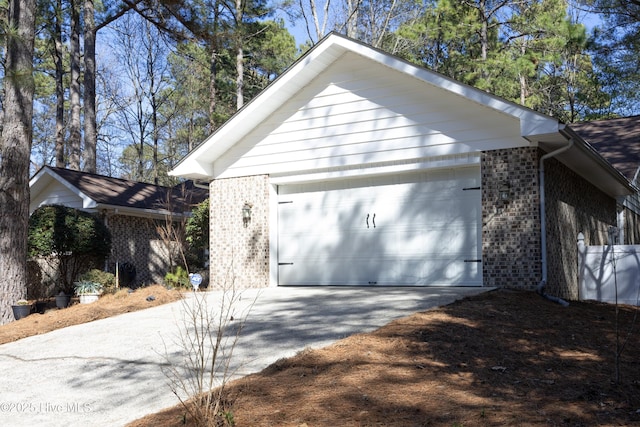 exterior space featuring a garage and brick siding