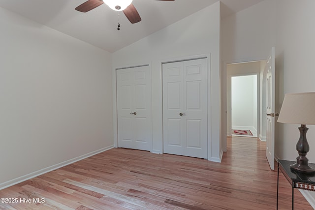 unfurnished bedroom with a ceiling fan, baseboards, lofted ceiling, and light wood-type flooring