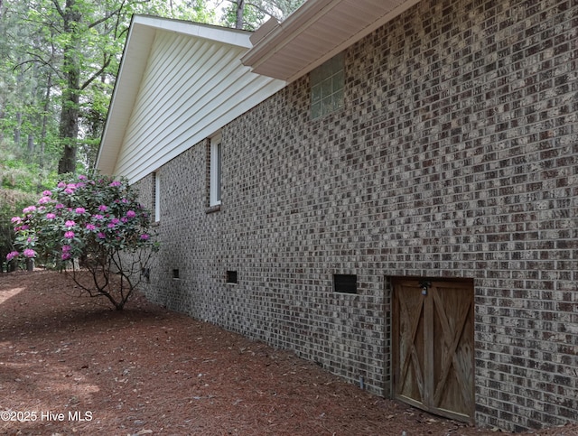 view of side of property with brick siding and crawl space