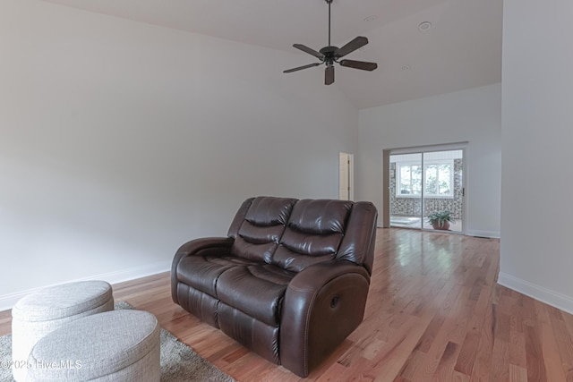 living area featuring baseboards, high vaulted ceiling, a ceiling fan, and light wood-style floors
