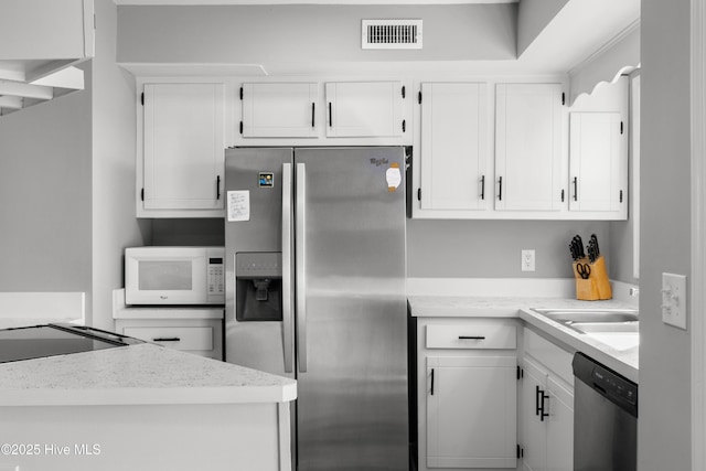 kitchen featuring a sink, visible vents, white cabinetry, and stainless steel appliances