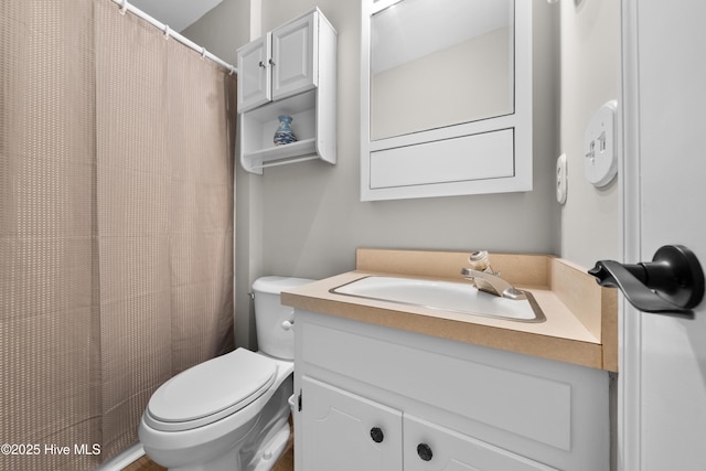 bathroom with vanity, a shower with shower curtain, and toilet